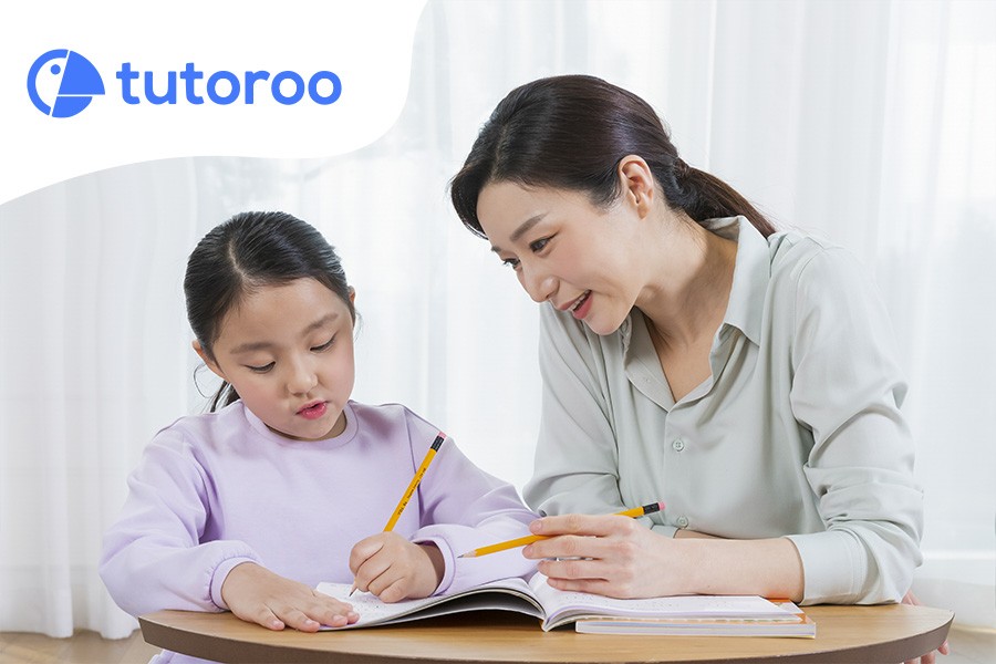 A woman and a child engaged in writing together, highlighting interactive learning in Singapore's language classes for kids