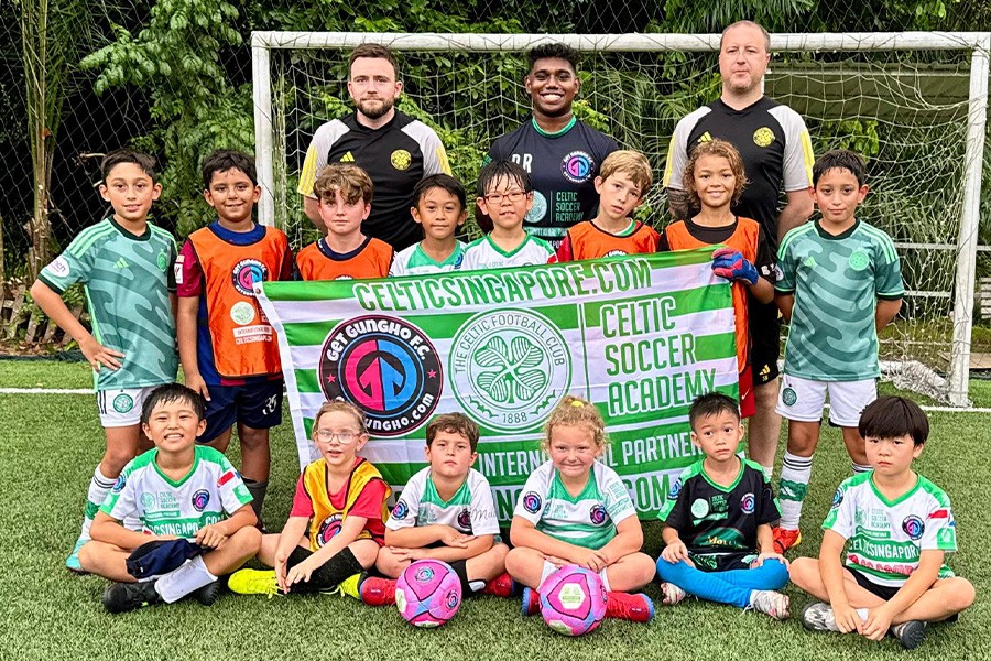 Happy kids with a soccer ball, enjoying the best year-end camps in Singapore